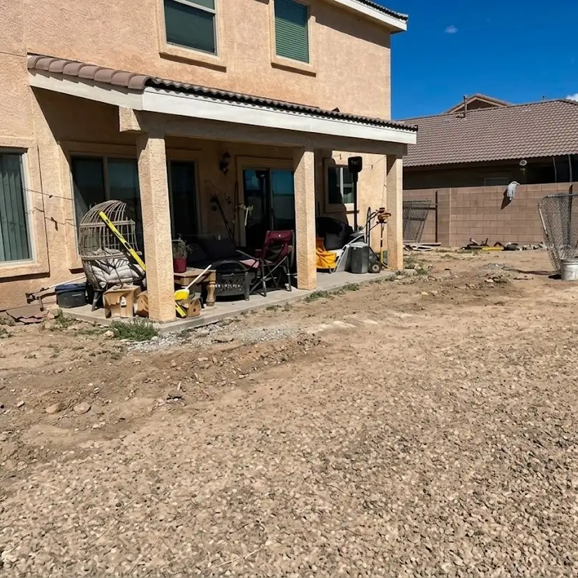 Before: a bare dirt backyard beside a covered patio